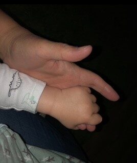 Baby holding an adult hand